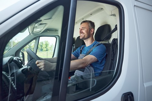An Alfa Moving driver in his truck driving to a destination.