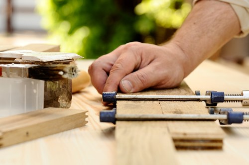 A person working on some furniture for recycling.