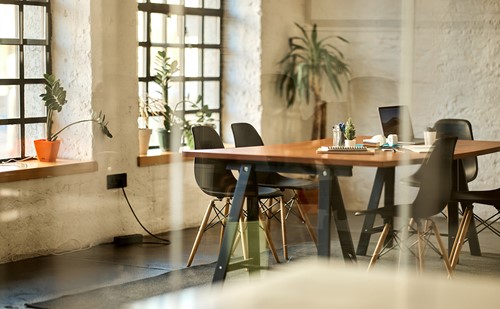 An office setting with chairs and table behind a glass wall.